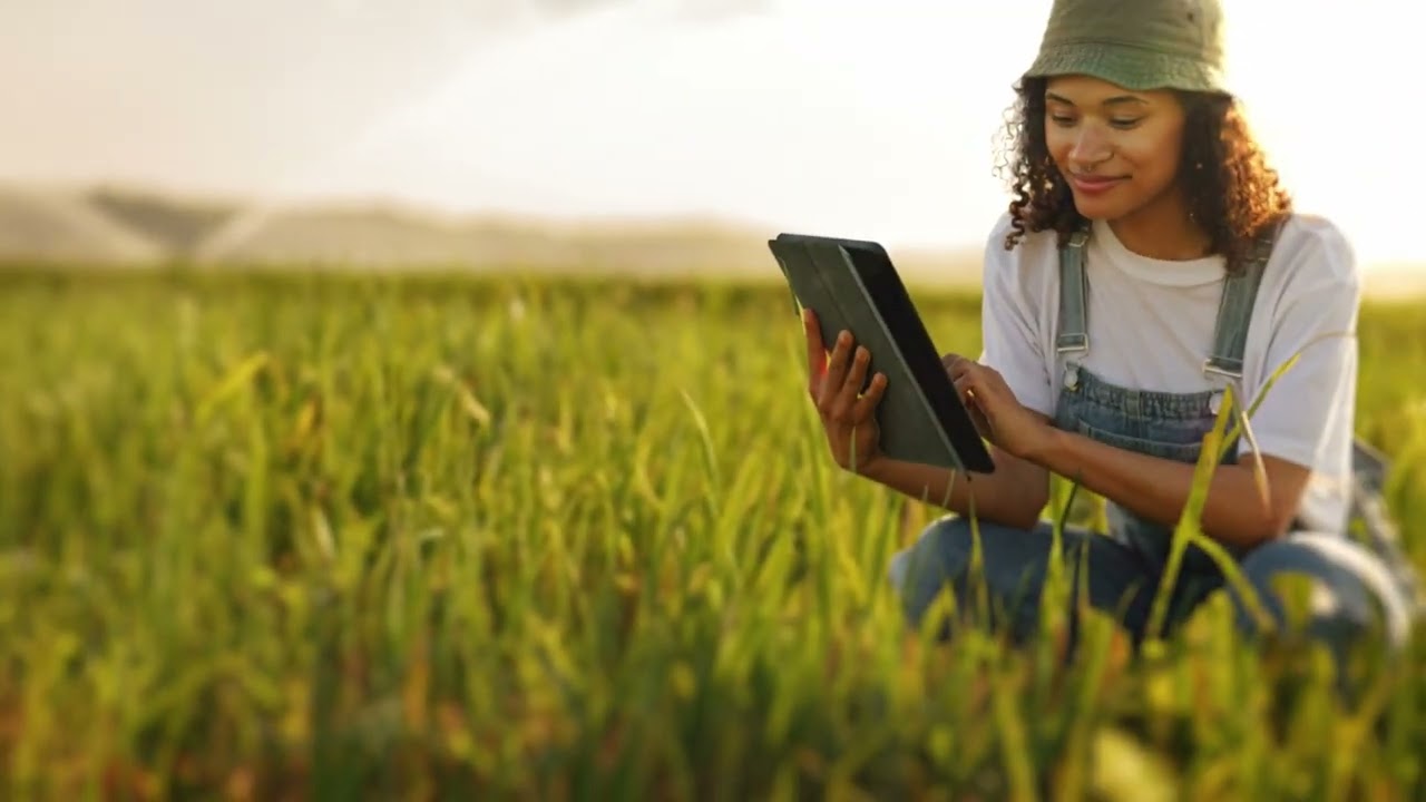 Person viewing a hand held tablet in a green field