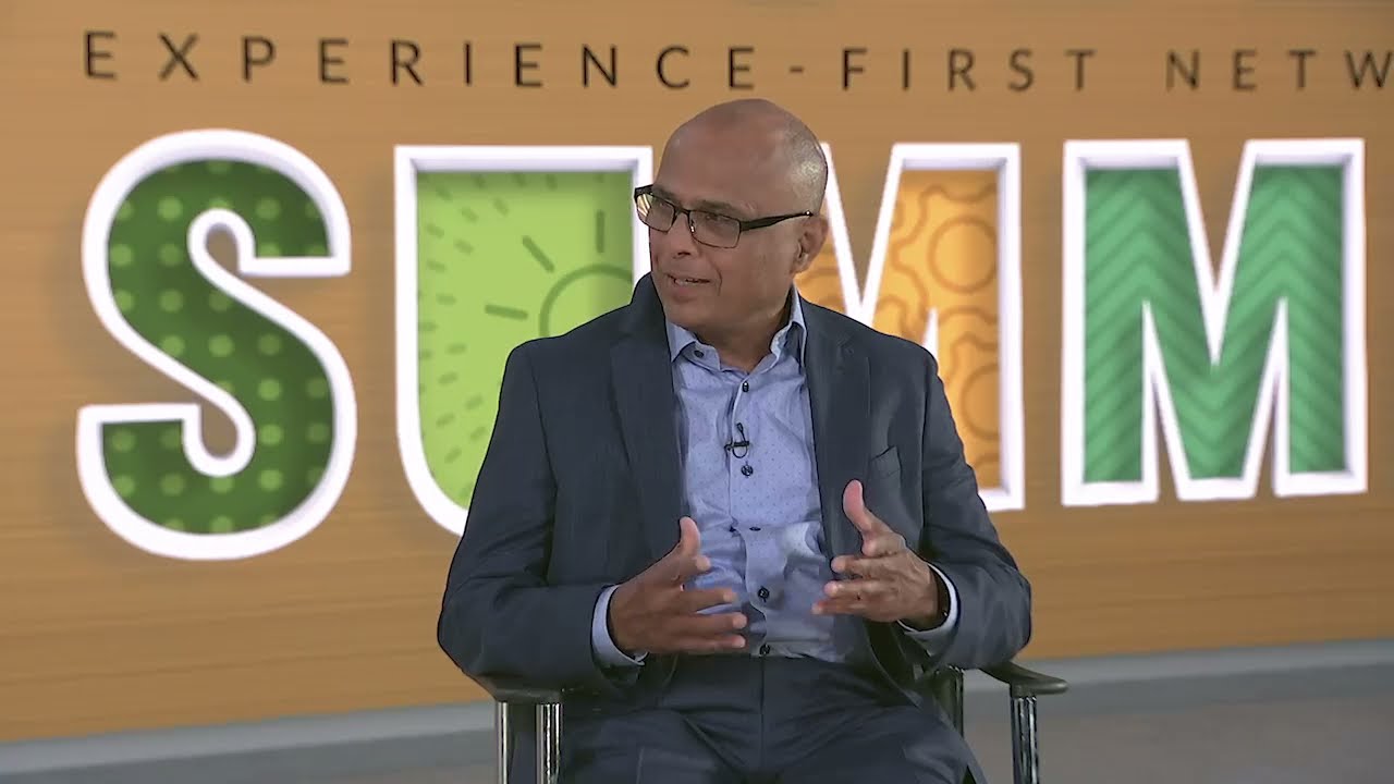 Raj Yavatkar, CTO, Juniper Networks, seated in a chair, looking left while talking in a video to Muhammad Durrani of Equinix about brownfield deployments, intent-based networking, and network as a service.